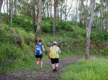 Two women walking along a trail.