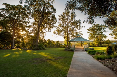 Grand rotunda at Highfields Peacehaven Botanic Park surrounded by lush green lawns and large shady trees. Looking out towards the Bunya Mountains.