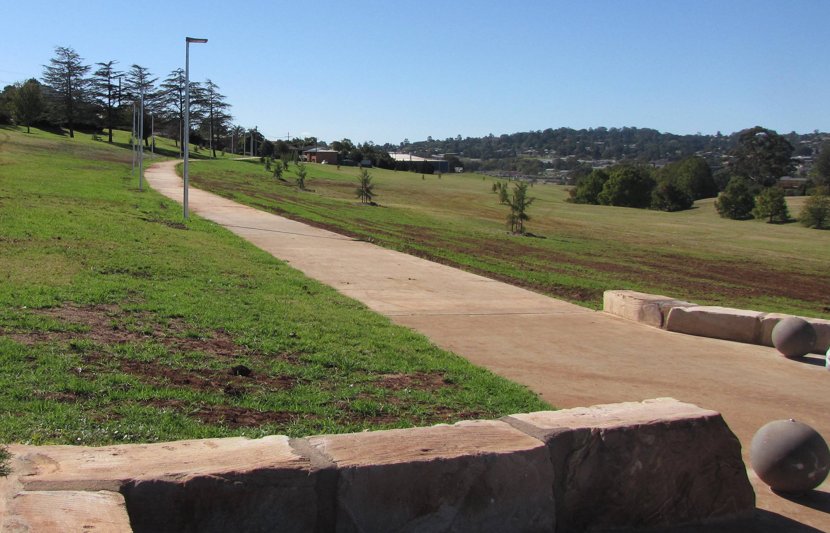 Black Gully parkland concrete path surrounded by open grass space.