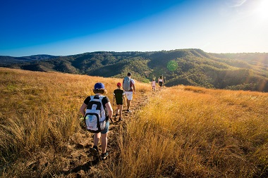 Family hiking on top of Table Top Mountain. View looking back towards Picnic Point. Clear blue skies.