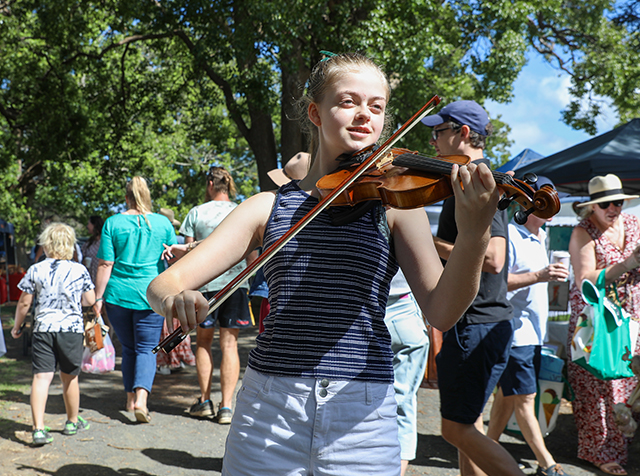 Girl playing violin at a local market